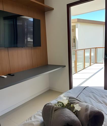a bedroom with a flat screen tv on a wall at MAR DÁ LIBERDADE com Amerigo Vespucci in Morro de São Paulo