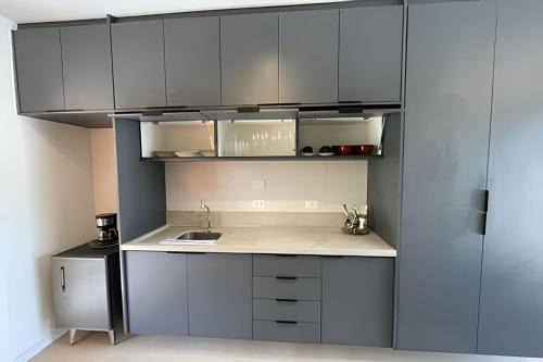 a kitchen with white cabinets and a counter top at MAR DÁ LIBERDADE com Amerigo Vespucci in Morro de São Paulo