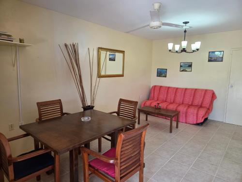 a living room with a table and a red couch at Nos Krusero Apartments in Sabana Westpunt