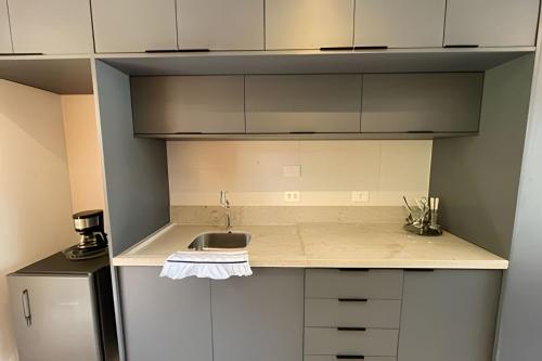 a small kitchen with a sink and a refrigerator at MAR DÁ LIBERDADE com Amerigo Vespucci in Morro de São Paulo
