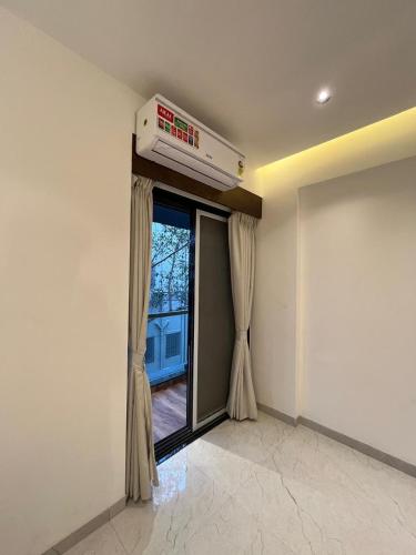 a room with a window with curtains and a air conditioner at Hotel Sai Residency in Pune