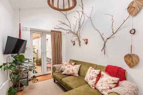 a living room with a green couch and a tv at Quirky Stay 10 min walk to city with free parking in York