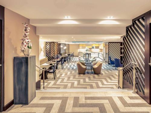 a lobby of a hotel with chairs and tables at Mercure Paris Arc de Triomphe Etoile in Paris