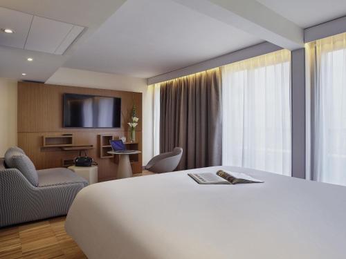 a hotel room with a large bed and a tv at Mercure Paris Arc de Triomphe Etoile in Paris