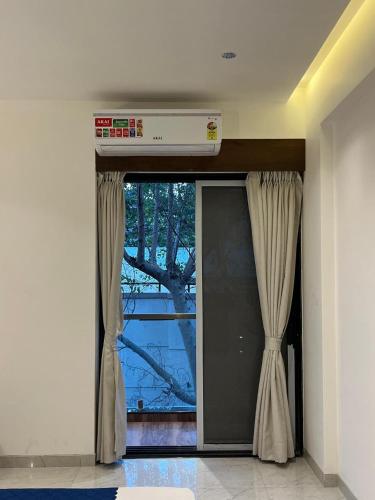 a door with curtains and a window in a room at Hotel Sai Residency in Pune