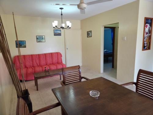 a living room with a red couch and a table at Nos Krusero Apartments in Sabana Westpunt
