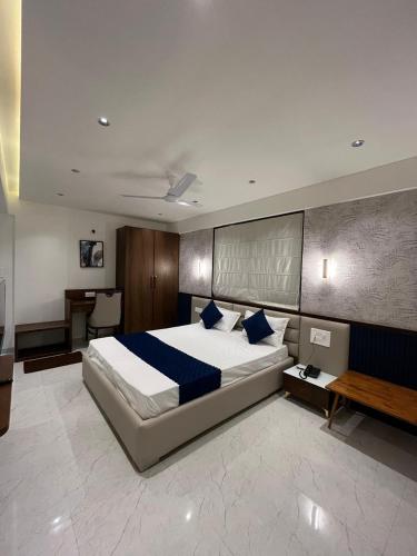 a bedroom with a large bed and a desk at Hotel Sai Residency in Pune