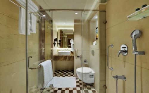 a bathroom with a toilet and a sink and a shower at Hotel NYASHA Ox Suites Near Delhi Airport in New Delhi