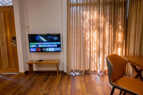 a living room with a flat screen tv and a table at Wilpattu Safari Resort in Wilpattu
