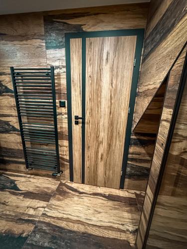 an open door in a room with wooden walls at Apartmán TatraNest in Nová Lesná