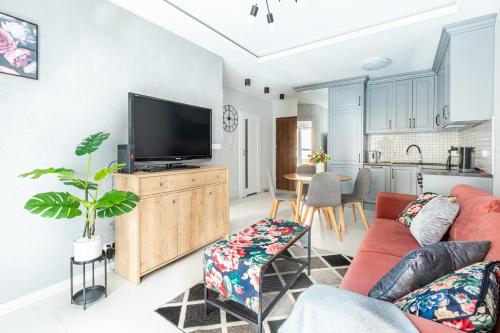 a living room with a flat screen tv on a wooden cabinet at Apartament GB przy PCK 3A z bezpłatnym parkingiem by Gingerbread Apartments in Toruń