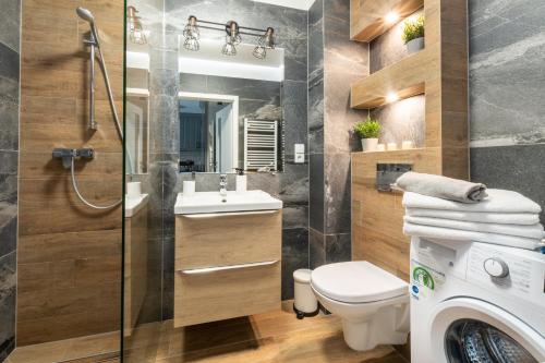 a bathroom with a shower toilet and a sink at Apartament GB przy PCK 3A z bezpłatnym parkingiem by Gingerbread Apartments in Toruń