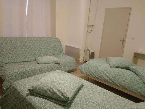 ein Wohnzimmer mit zwei Betten und einer Couch in der Unterkunft Appartement rez de chaussé 60m2 in Montreuil-sur-Ille