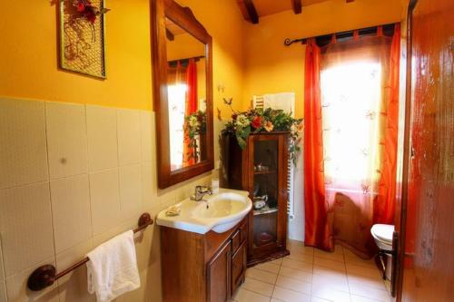 La salle de bains est pourvue d'un lavabo et d'un miroir. dans l'établissement Casa Vacanza Le Corniole, à Civitella in Val di Chiana