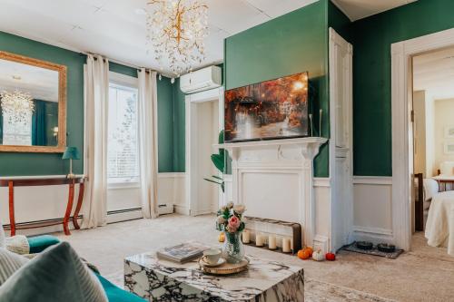 a living room with a fireplace and green walls at The Underwood-Hale House in Providence