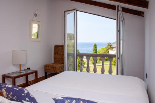 a bedroom with a bed and a view of the ocean at Villa Delfin Rab in Supetarska Draga