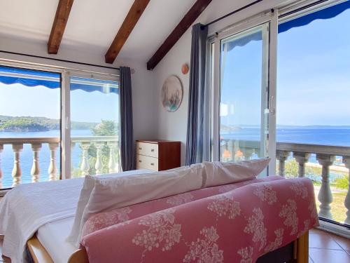 a bedroom with a bed and views of the ocean at Villa Delfin Rab in Supetarska Draga