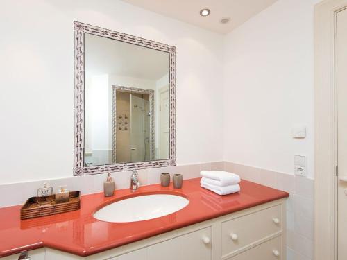 a bathroom with a red sink and a mirror at Biike Hüs von Appartements & Mehr in Kampen
