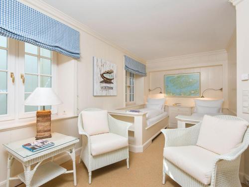 a living room with white chairs and a table at Biike Hüs von Appartements & Mehr in Kampen