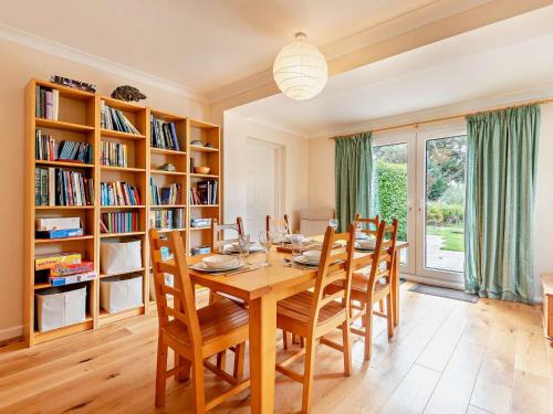 a dining room with a table and chairs and bookshelves at 4 Bed in Studland 75639 in Studland