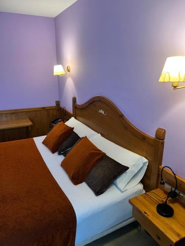 a bedroom with a bed with brown and white pillows at Petit Hotel in Pas de la Casa
