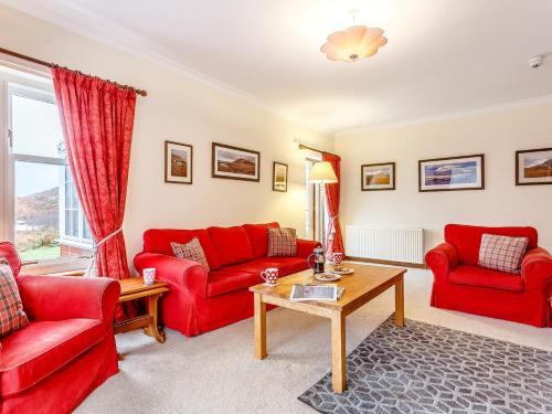 a living room with red couches and a table at 6 Bed in Lairg CA210 in Achlyness