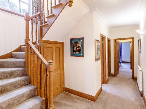 a staircase in a home with white walls and wooden railings at 6 Bed in Lairg CA210 in Achlyness