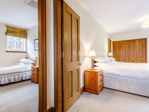 two beds in a bedroom with a door open at 6 Bed in Lairg CA210 in Achlyness
