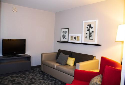 a living room with a couch and a tv at Country Inn & Suites by Radisson, Carlisle, PA in Carlisle