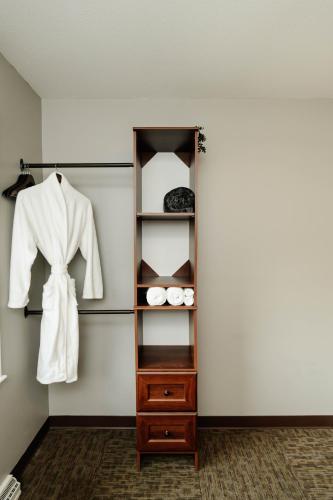 a closet with a white jacket and a wooden shelf at Sonlit Retreats in Skyline
