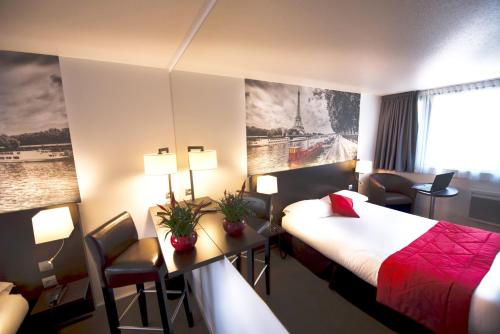 Habitación de hotel con cama y escritorio en Hotel Pavillon des Gatines en Plaisir