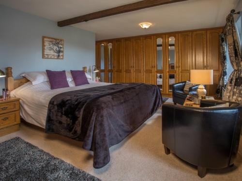 コニストンにある5 Bed in Coniston LCC28の大きなベッドと椅子のある寝室