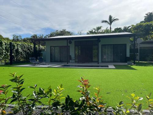 a house with a green lawn in front of it at Casa Flor in Playa Avellana