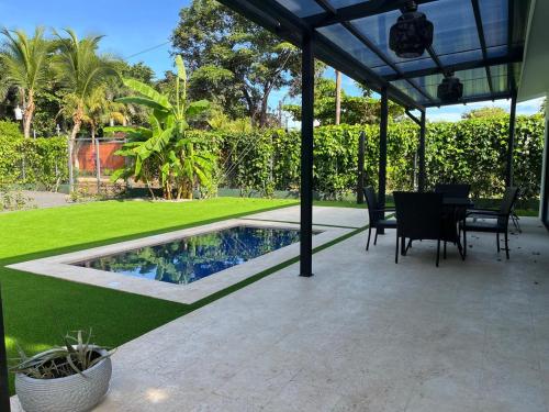 a patio with a table and chairs and a swimming pool at Casa Flor in Playa Avellana