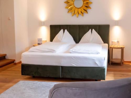 a bedroom with a large bed with a green headboard at Hubertus Boutiquehotel Filzmoos in Filzmoos