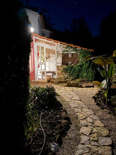 a house with a light on the side of it at Nativo Natureza Pink Wood Cabin in Cela
