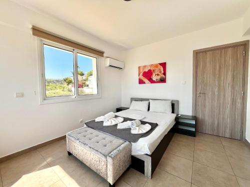 a bedroom with a large bed and a window at STAY Symphony Apartment in Protaras
