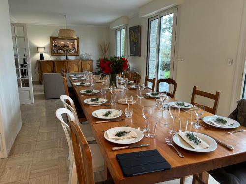 ErbréeにあるMaison de campagneの木製の長テーブル(皿、ワイングラス付)