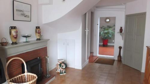 a living room with a fireplace and a staircase at Chambres d’hôtes Chantal Hereaudeau in Les Moulins de la Boire