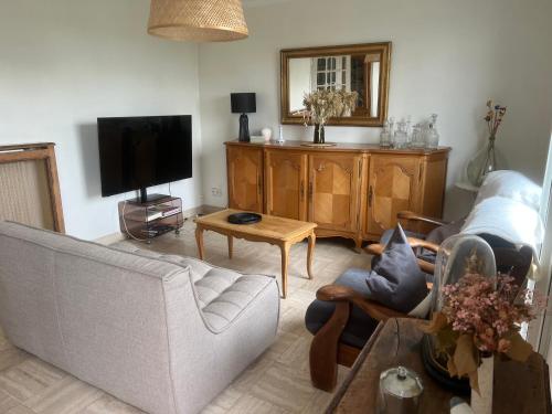 ErbréeにあるMaison de campagneのソファとテレビのあるリビングルーム