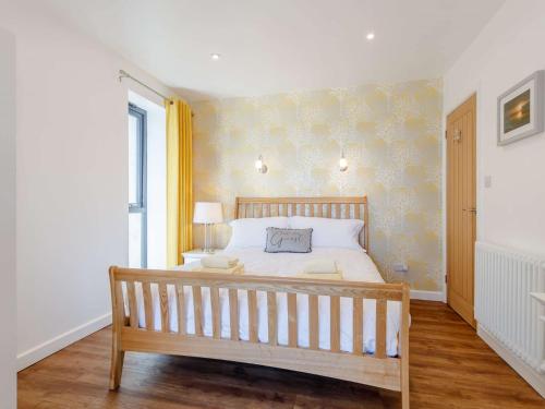 a bedroom with a large bed with a wooden bench at 1 Bed in Kewstoke 78986 in Weston-super-Mare