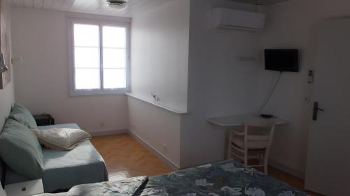 a living room with a bed and a window at Chambres d’hôtes Chantal Hereaudeau in Les Moulins de la Boire