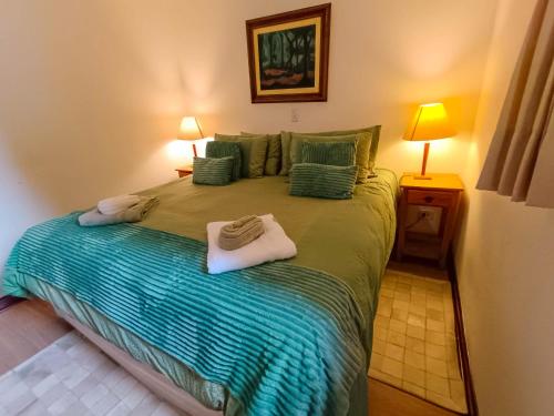a bedroom with a large bed with towels on it at Pousada Hortelã in Campos do Jordão