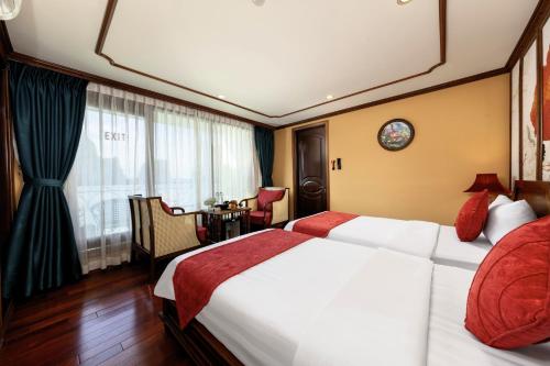 a hotel room with a large bed and a table at Verdure Lotus Grandeur Cruise on Ha Long Bay in Ha Long