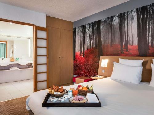 a hotel room with a tray of food on a bed at Novotel Paris Est in Bagnolet