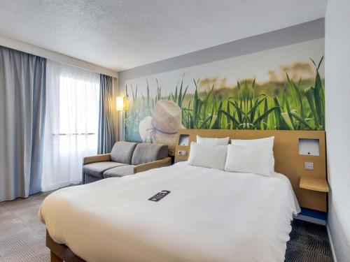 a hotel room with a large bed and a chair at Novotel Paris Est in Bagnolet