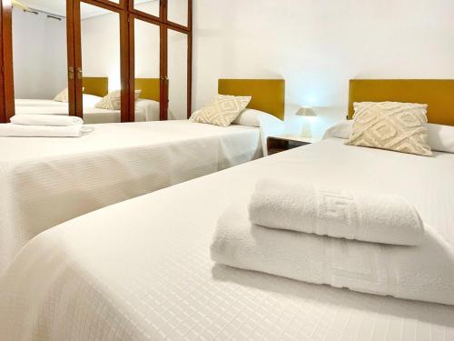 a bedroom with two beds with white sheets at Lope de Vega by Kaleria Suites in Almería