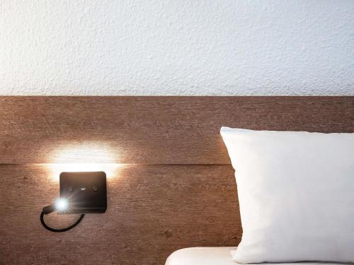 a lightswitch on a wall next to a bed at Novotel Paris Est in Bagnolet