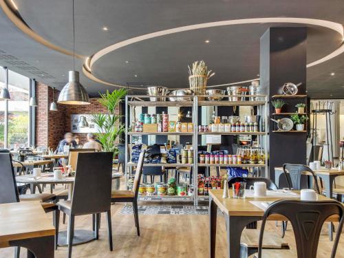 a restaurant with tables and chairs in a room at Novotel Paris Est in Bagnolet