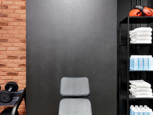 a room with a chair and a brick wall at Novotel Paris Est in Bagnolet